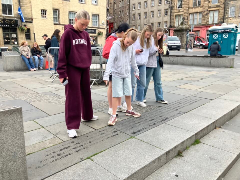 Pupils reading a clue on the pavement during an Edinburgh school treasure hunt