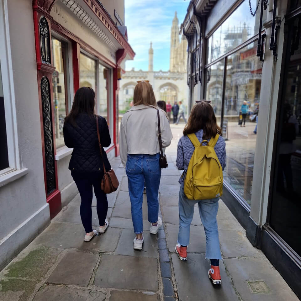 Small group walking down a narrow historic shopping street as part of a treasure hunt tour.