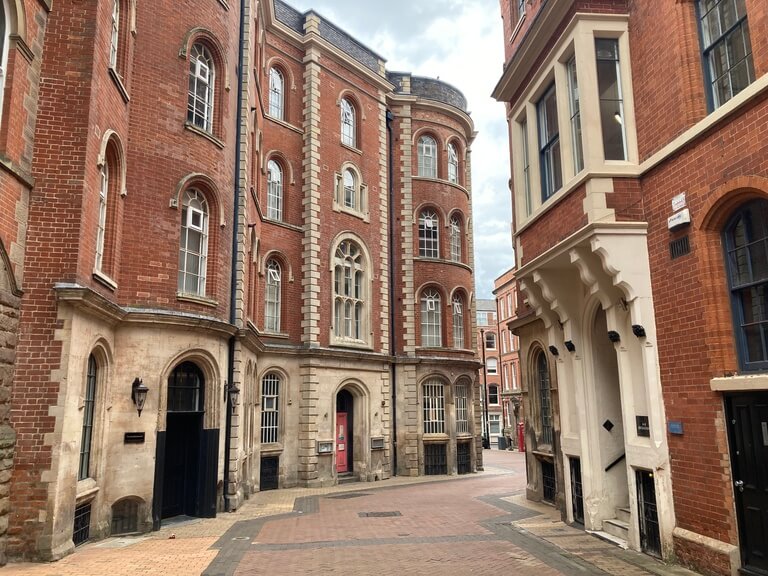 A brick pedestrianised street lined with old warehouses